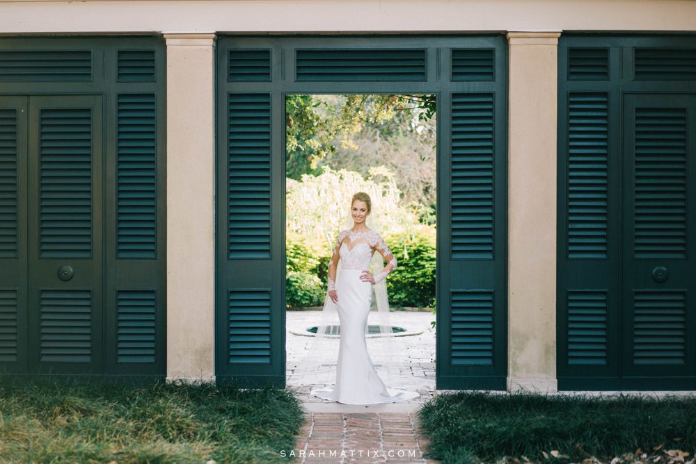 bride standing by green shutters